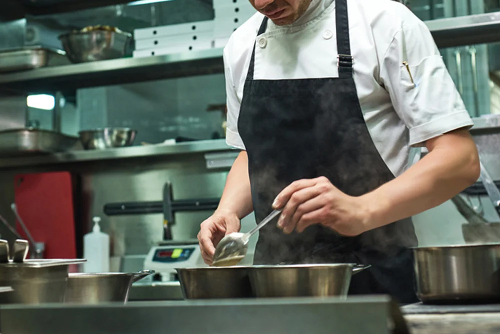 Le chef cuisine des produits frais au Restaurant Partage